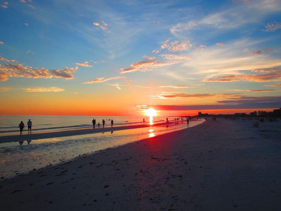 people walking along beach beautiful sunset